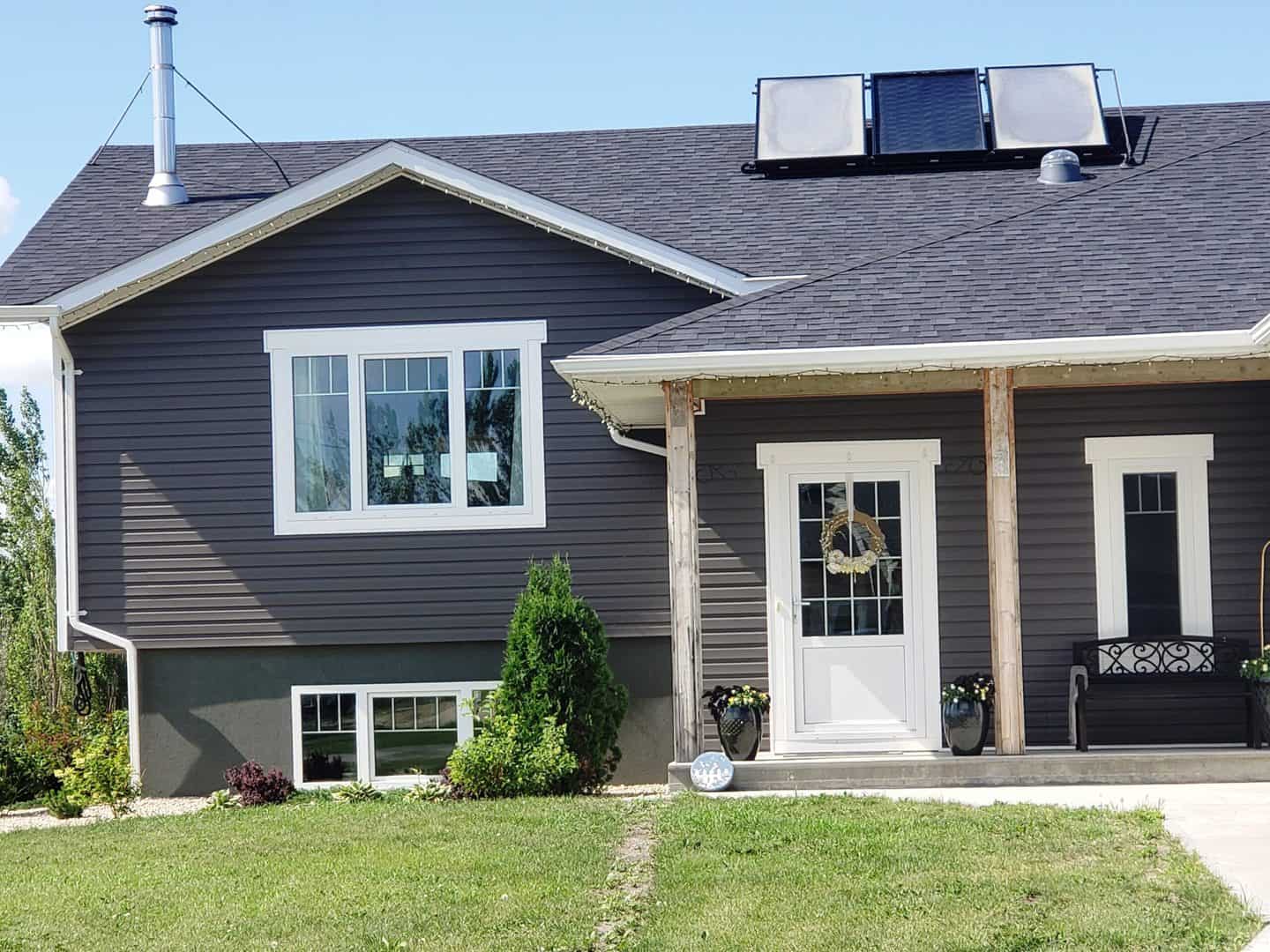 European windows with white trims in grey house with white European door